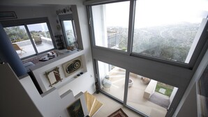 Apartamento moderno em prédio alto, com varanda ampla e vista para a cidade.