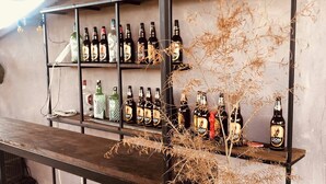 A bar area with shelves of bottles, a wooden table, and a bench.