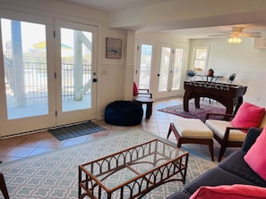 A living room with a sofa, coffee table, and a foosball table.