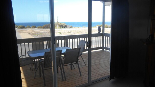 A balcony with a table and chairs, overlooking a beach and the ocean. - The White House ~ Free Wi-Fi, Arcade Machine - Off Peak Special! (Edithburgh)