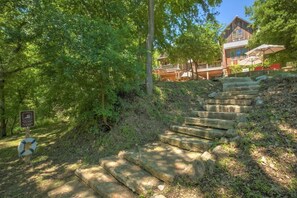 A wooden staircase leading to a cabin surrounded by dense trees. - Life is Gruene-Riverfront Luxury-1Mi To GrueneHall (New Braunfels)