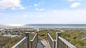 A wooden boardwalk leading to a beach with a clear sky. - Oceanfront retreat in Holden Beach, 4BR, 3BA, sleeps 10 with stunning views! (Holden Beach)
