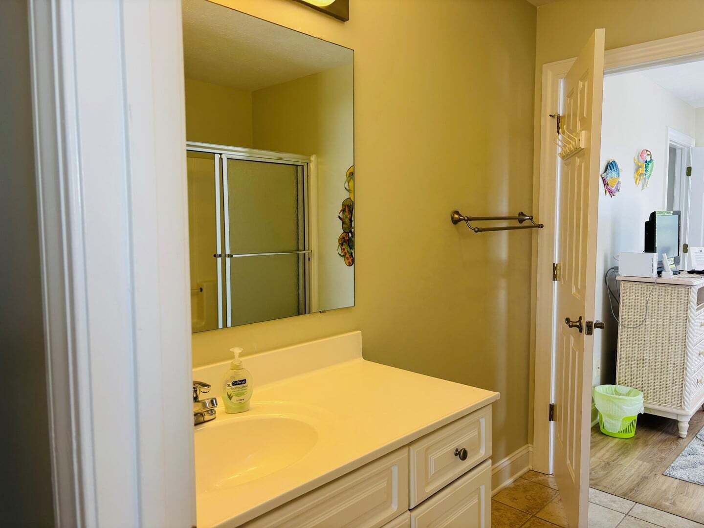 A bathroom with a white sink, a mirror, and a shower door.