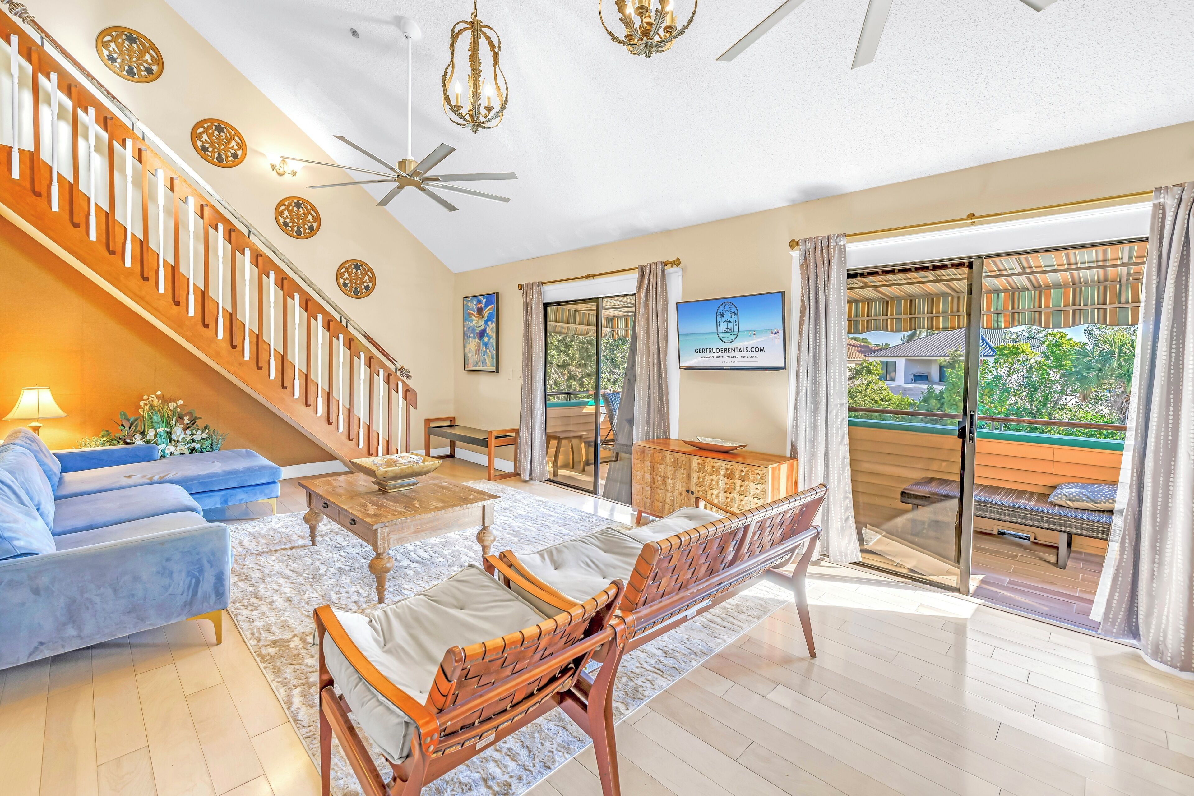 A spacious living room with a staircase, a sofa, a coffee table, and a dining area.