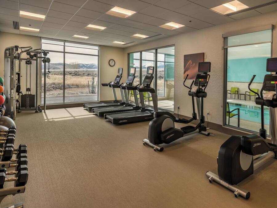 A gym with treadmills, elliptical machines, and weightlifting equipment.