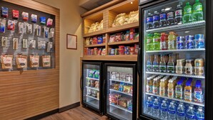 A refrigerated display case stocked with bottled water, juices, and other beverages.