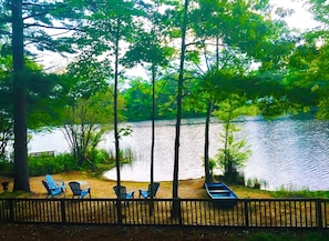 A lakeside view with a wooden deck, chairs, and a boat. - Waterfront Quiet Retreat, Plymouth, Pet Paradise, Private Beach, Sleeps 4 (Plymouth)