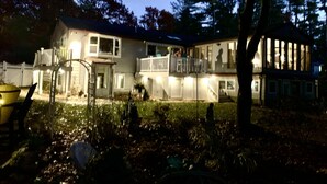 A two-story house with a fenced yard, a covered porch, and a visible garage. - Waterfront Quiet Retreat, Plymouth, Pet Paradise, Private Beach, Sleeps 4 (Plymouth)