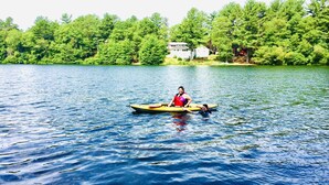 A calm lake with a small yellow boat and a person in a red life jacket. - Waterfront Quiet Retreat, Plymouth, Pet Paradise, Private Beach, Sleeps 4 (Plymouth)