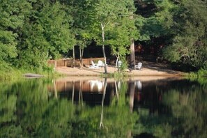 Escape to a serene natural oasis with a tranquil body of water and shaded seating areas.