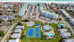 An aerial view of a coastal hotel with multiple buildings, a tennis court, and a swimming pool. - PET FRIENDLY, Private Beach Access, Beach Setup, Pools, HotTub, Tennis/Pickleball, Maravilla 1st Fl (Miramar Beach)