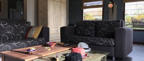 Un salon avec un canapé, une table basse et un meuble.