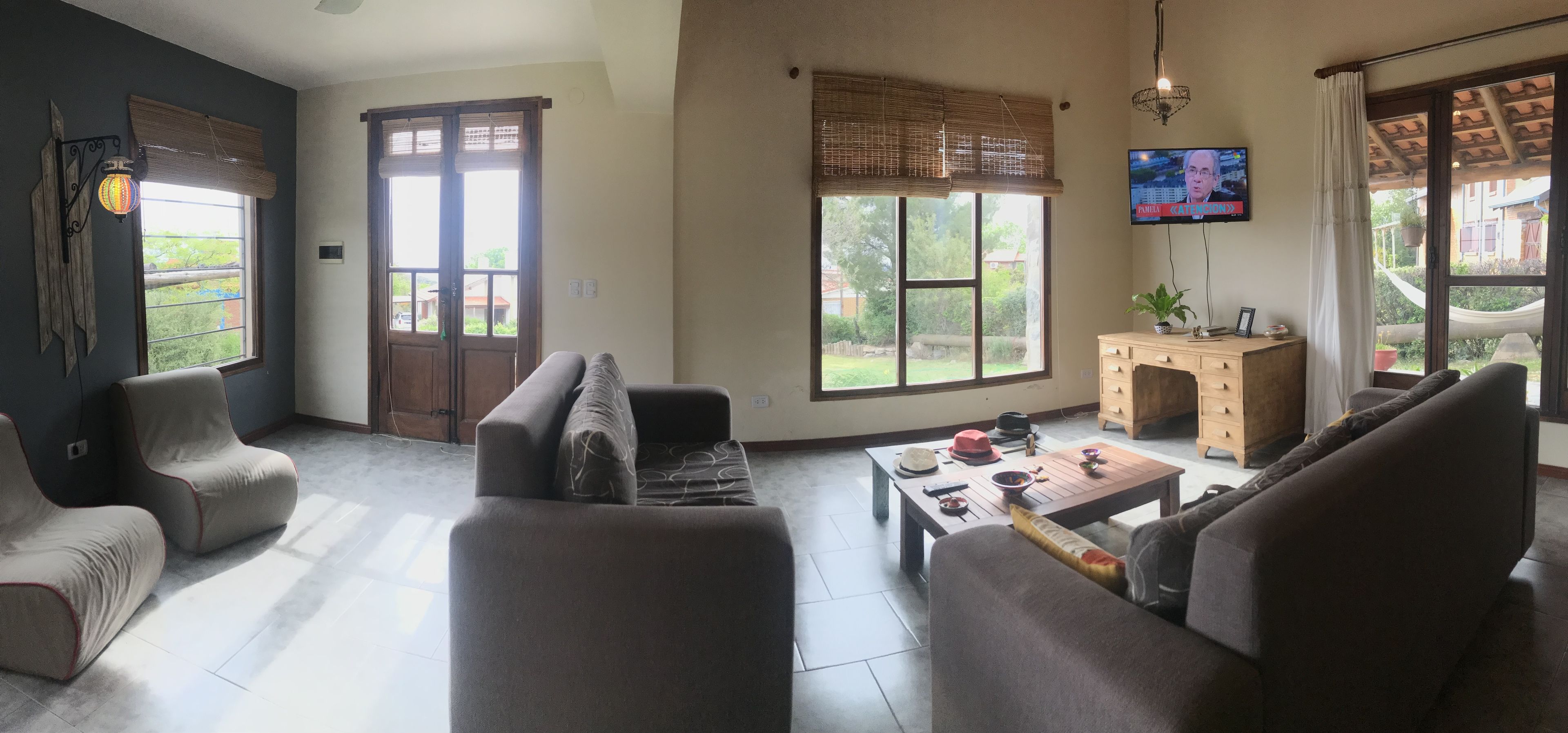 Una sala de estar con un sofá, sillones, una mesa de centro y un televisor.