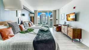 Een moderne hotelkamer met een groot bed, een houten kast en uitzicht op de stad.
