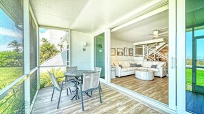 Un intérieur moderne comprenant un coin repas, un salon avec un canapé et une table basse, ainsi qu’un escalier menant à un niveau supérieur.