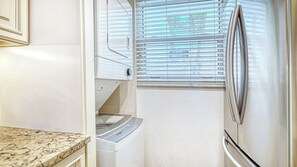 A compact kitchen with a built-in refrigerator, a microwave, and a water dispenser. - LaPlaya 102B-Directly on the beach with the warm Gulf waters waiting! (Longboat Key)
