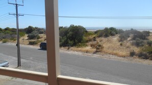 A road with sparse vegetation and a clear sky. - Hardwicke Espy   close to beach (Hardwicke Bay)