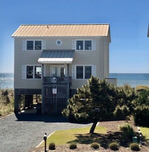 Situated near a body of water, this building offers a scenic view from its upper balcony.
