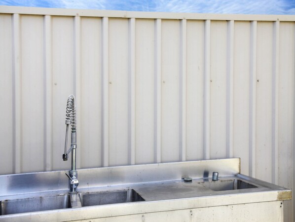 A metal sink with a faucet against a corrugated metal wall. - Blue Door Retreat - Excellent Off Peak Special! Nightly rates reduced!! (Edithburgh)