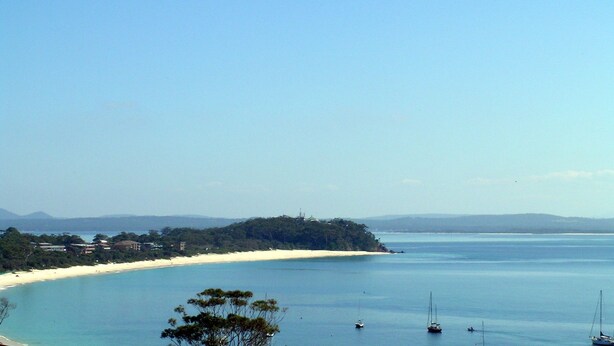 A coastal landscape with a sandy beach, calm sea, and a few boats. - Blue Waters Unit 8/59 Ronald Ave, Shoal Bay - This cosy unit has the views and the position! (Shoal Bay)