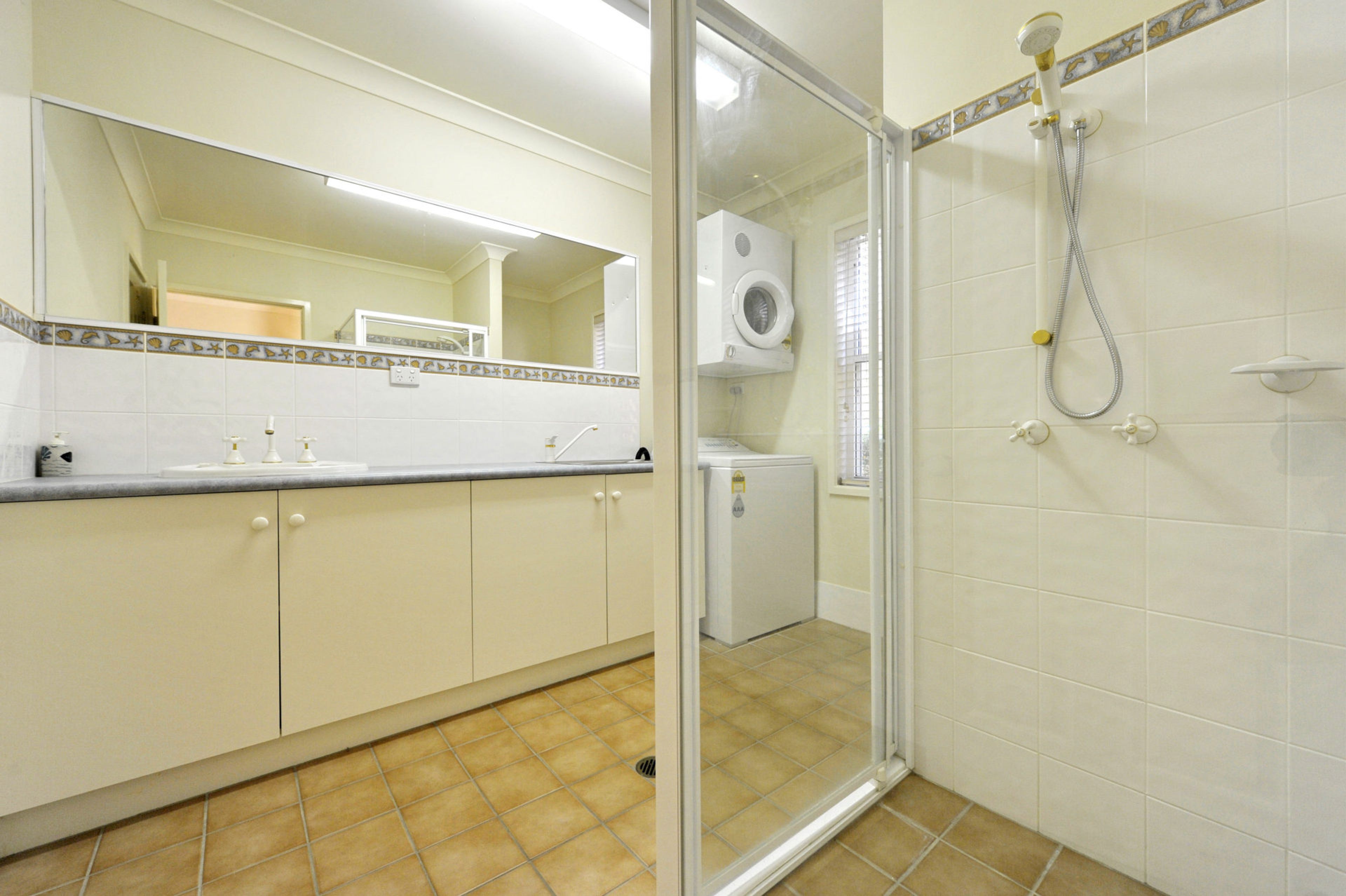 A bathroom with a shower, a toilet, and a sink.