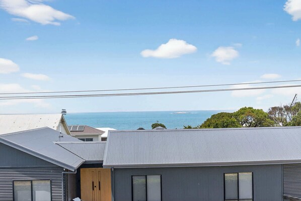 A residential building with a view of the sea and a distant island.