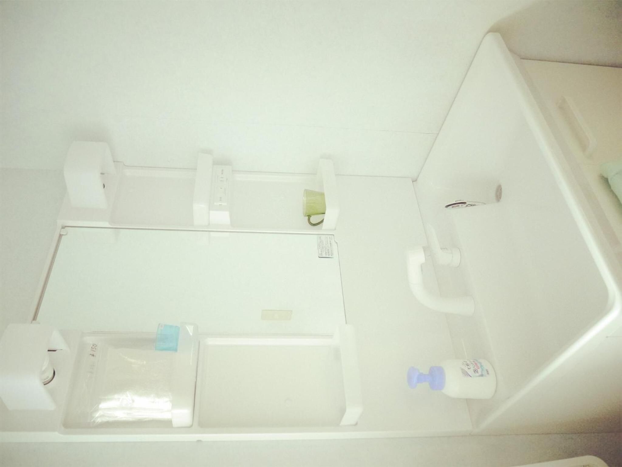 Un baño con inodoro, lavamanos y un pequeño espacio de almacenamiento.