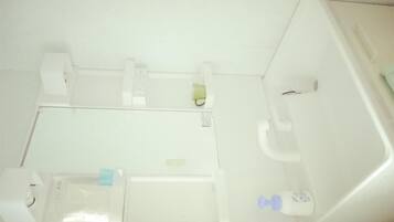 Een badkamer met toilet, wastafel en een klein opbergplaatsje.