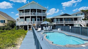 A two-story building with a pool, a deck, and a view of the ocean. - Oceanfront oasis in Holden Beach! Spacious 6BR, 6BA, sleeps 14. (Holden Beach)