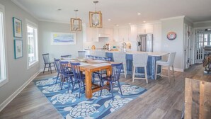 A spacious kitchen with white cabinets, a central island, and pendant lighting. - Oceanfront oasis in Holden Beach! Spacious 6BR, 6BA, sleeps 14. (Holden Beach)