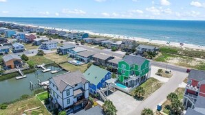 A coastal residential area with houses, a dock, and a beach. - Oceanfront Heaven's Anchor in Holden Beach, 3BR, 2BA, perfect for family fun! (Holden Beach)