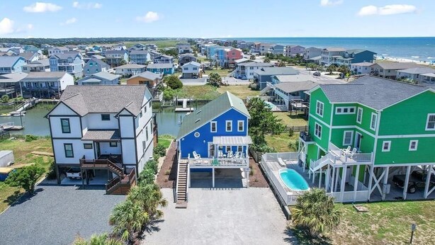 A coastal residential area with houses, a swimming pool, and a dock. - Oceanfront Heaven's Anchor in Holden Beach, 3BR, 2BA, perfect for family fun! (Holden Beach)