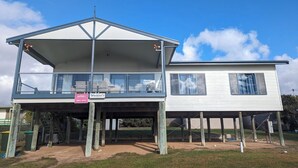 A two-story house with a balcony on the upper floor. - Woody's Beach House ~ Beautiful Sea Views, Great Position,  Off Peak Special! (Point Turton)