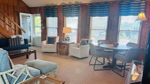 A cozy living room with a sofa, chairs, a coffee table, and a dining area with a table and chairs. - Dry Dock / 150 Tarpon: Spacious 4-bedroom home in Holden Beach with canal views. (Holden Beach)
