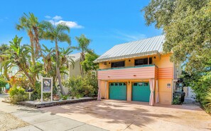 A two-story building with a flat roof, a balcony, and a garage.