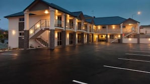A multi-story hotel with a central courtyard, multiple balconies, and a covered entrance.