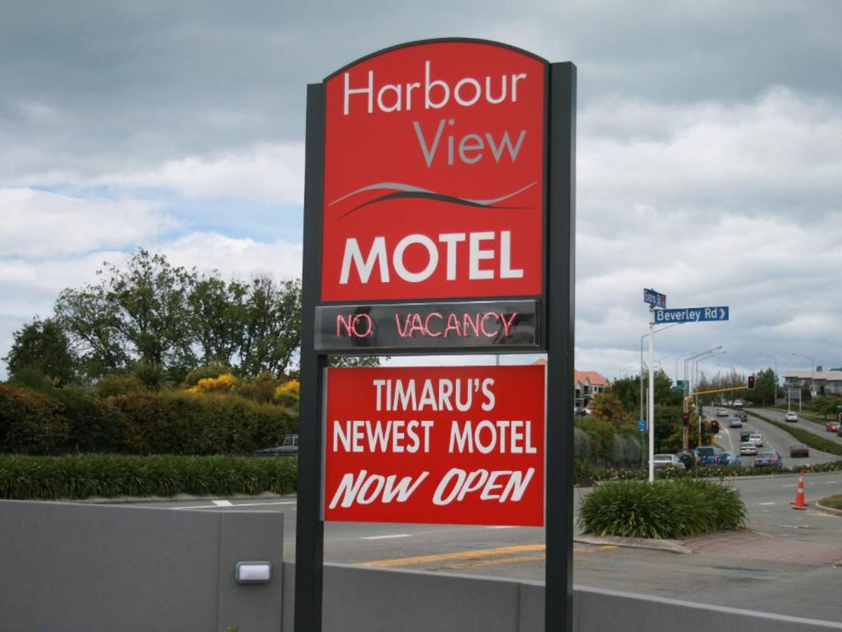 Segnaletica motel con la scritta 'Harbour View' e 'Nuovissimo Motel di Timaru, ora aperto'.
