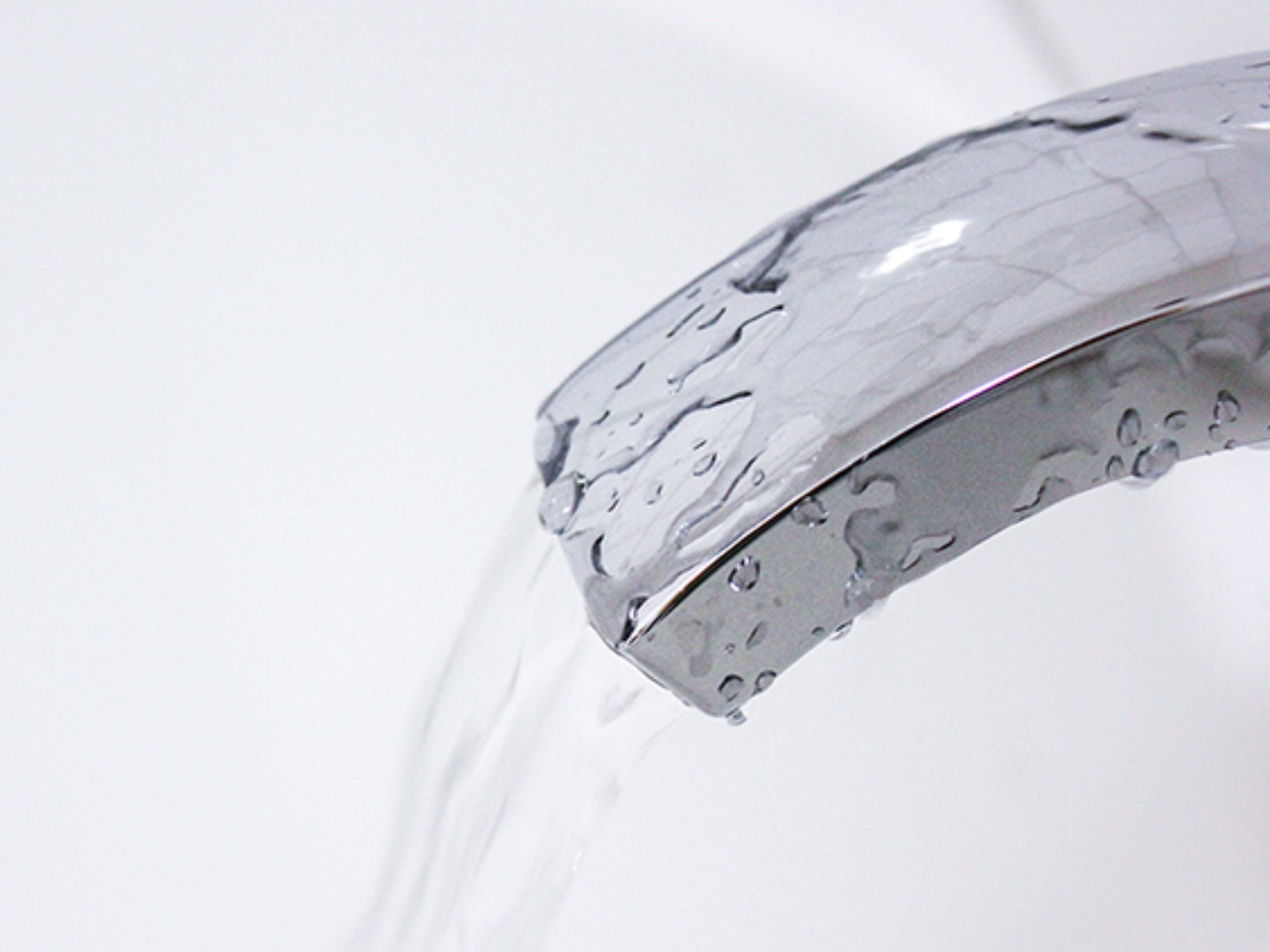 A close-up of a faucet with water flowing from it.