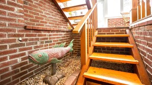 Een trap met houten treden en een bakstenen muur.