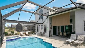 A covered outdoor swimming pool with lounge chairs and a patio area. - 6BR Pool Home Windsor Palms by SHV-2238 (Kissimmee)