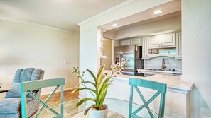 A modern kitchen with white cabinets, stainless steel appliances, and a central island. - LaPlaya 109A-Enjoy the balmy breezes in this corner end unit right on the beach. (Longboat Key)