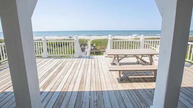 A wooden deck with a bench and railing overlooking a beach. - Paw-Paw's Place: Spacious 6BR oceanfront home in Holden Beach, sleeps 14! (Holden Beach)