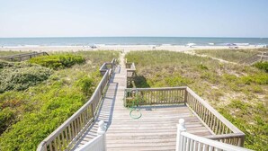 A wooden boardwalk leading to a beach with a clear view of the ocean. - Paw-Paw's Place: Spacious 6BR oceanfront home in Holden Beach, sleeps 14! (Holden Beach)