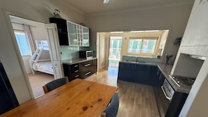 A compact kitchen with a dining area, a built-in microwave, and a small sink.