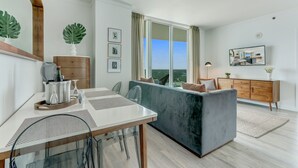 Una sala moderna con un sofá, una mesa de comedor y una zona de cocina.
