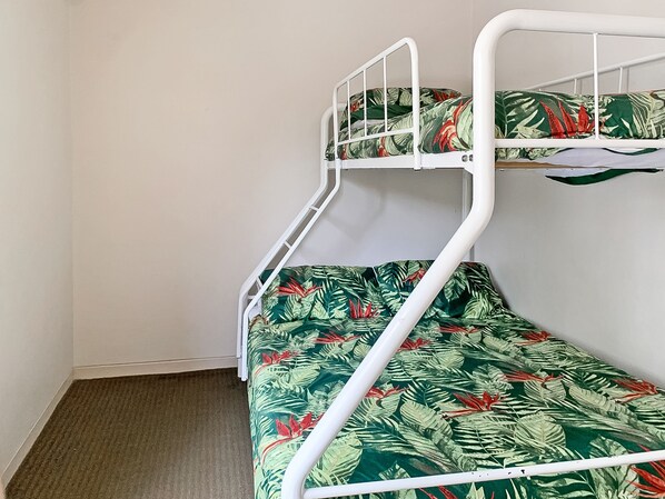 A bunk bed with a tropical leaf pattern bedspread.