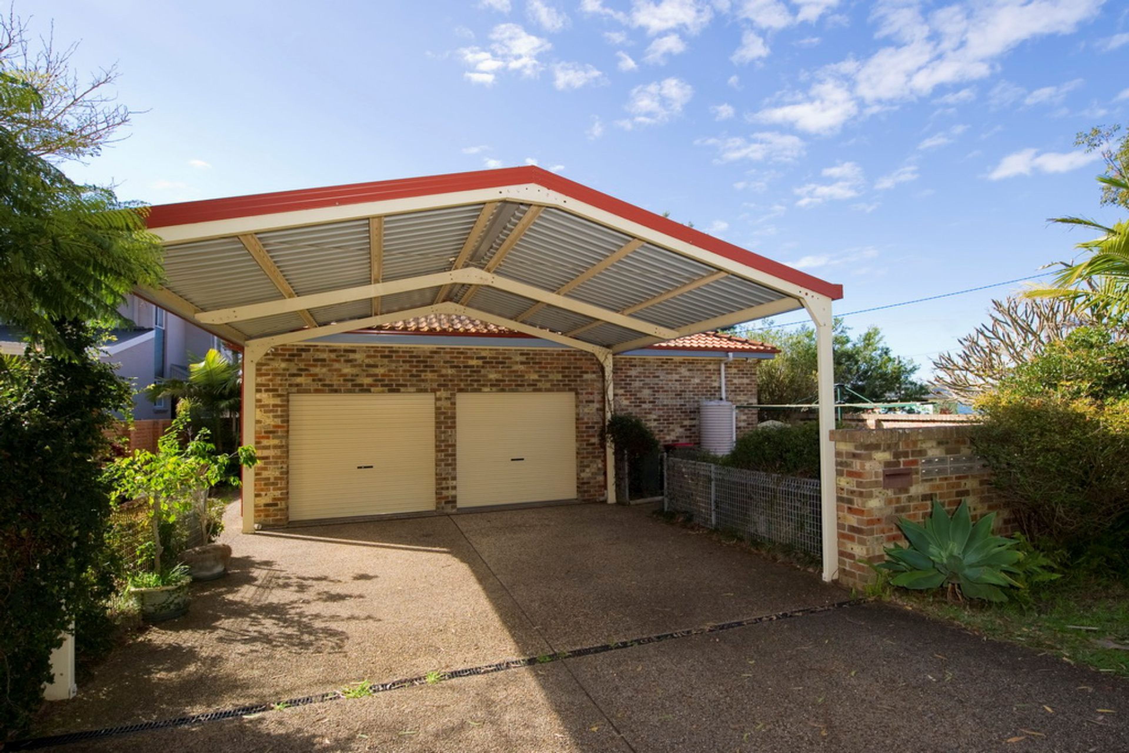 A two-car garage with a metal roof and brick walls.