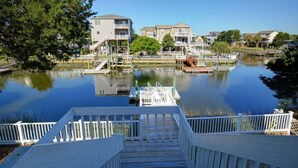 A waterfront property with a dock, a staircase leading to a building, and a clear view of the water. - Charming oceanfront retreat, Sea Shanty / 153 Marlin, with 3 beds in Holden Beach. (Holden Beach)