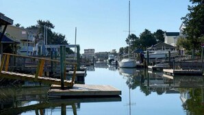 A marina with boats docked, wooden walkways, and buildings in the background. - Charming oceanfront retreat, Sea Shanty / 153 Marlin, with 3 beds in Holden Beach. (Holden Beach)