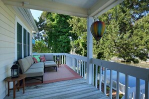 A covered porch with a sofa, a small table, and a hanging lantern.
